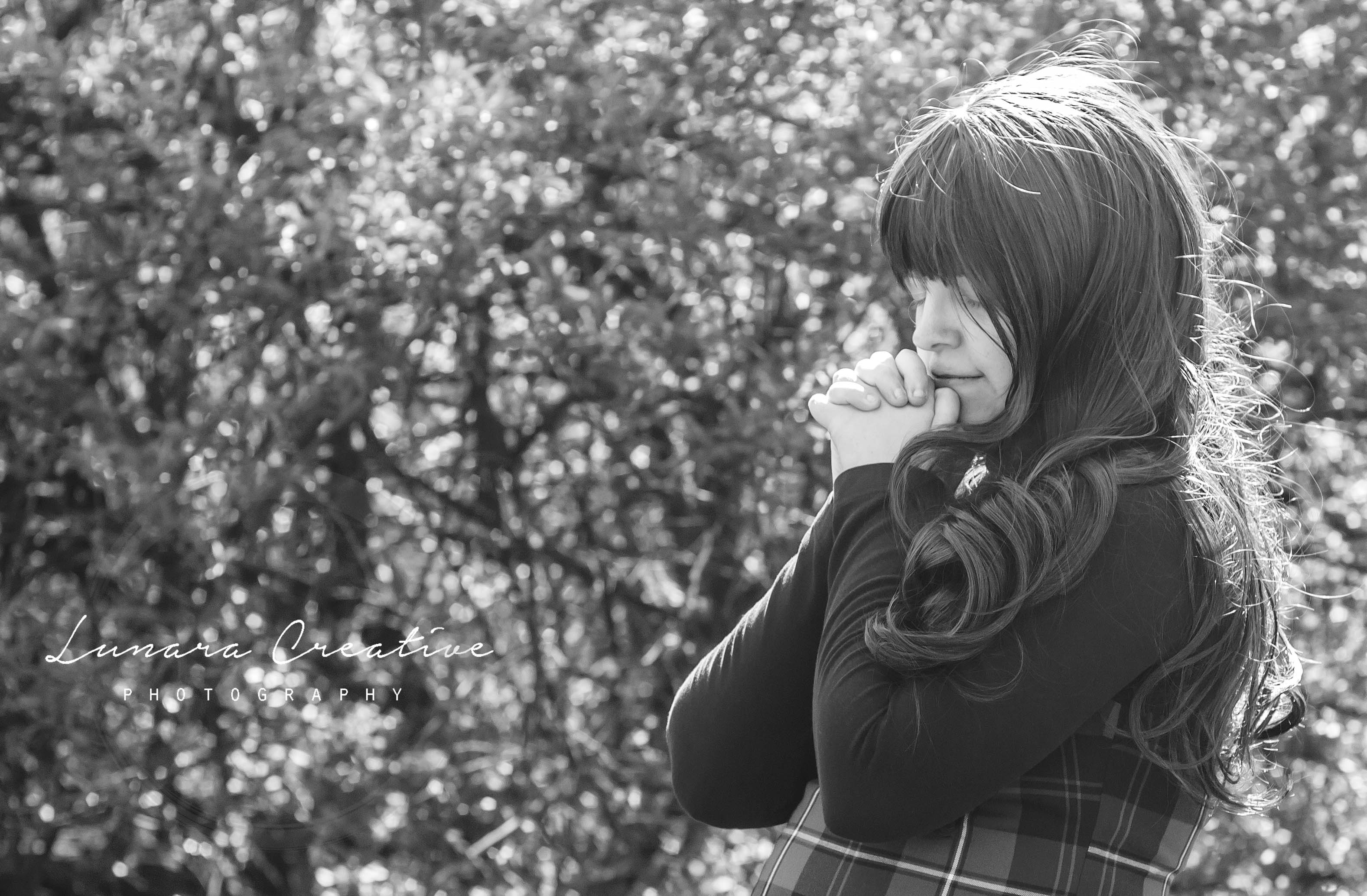 Prayer A young woman saying a short pray in a field. by Lunara Creative Photography