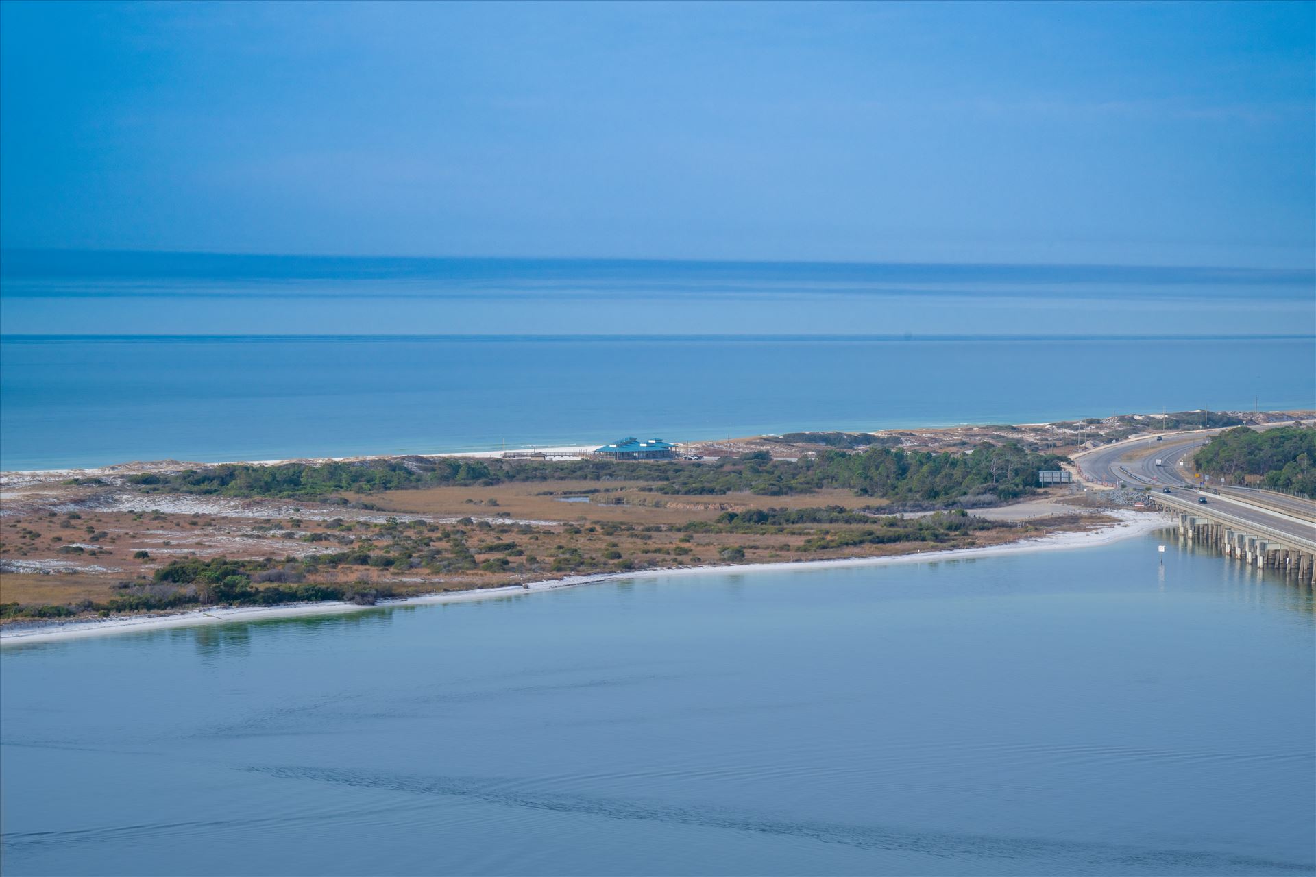 Destin, Florida, where the bridge stretches over crystal-clear water Destin, Florida, where the bridge stretches over crystal-clear waters, leading to pristine white sand beaches under the warm coastal sun. by Terry Kelly Photography