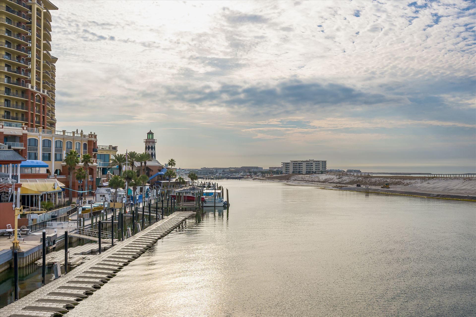 Destin Harbor water sky Destin Harbor's serene waters reflect the drifting clouds, with walkway, boat dock, and, condos lining the shore beneath the expansive sky. by Terry Kelly Photography