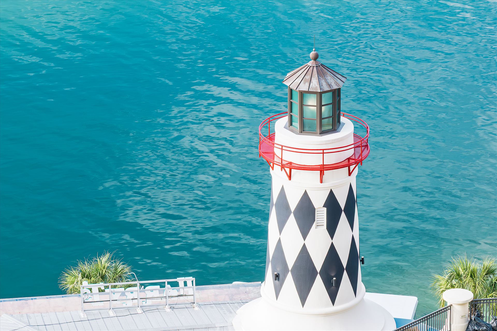 lighthouse near edge of salt water lighthouse near edge of salt water red railing looking down at lighthouse by Terry Kelly Photography