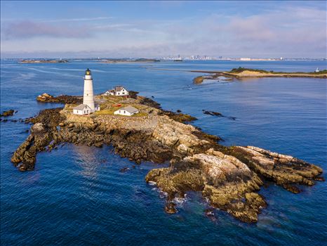 The modern Boston Harbor waterfront guarded by Boston Light, America's oldest lighthouse, in Boston Harbor, Boston, Massachusetts by New England Photography