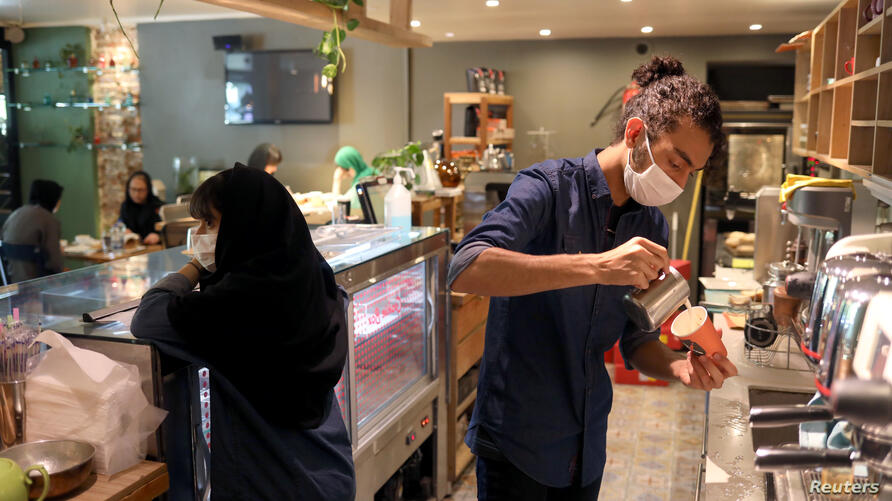 A worker wearing a protective face mask prepares a coffee at a coffee shop, following the outbreak of the coronavirus disease (COVID-19), in Tehran, I  by mohsen dehbashi