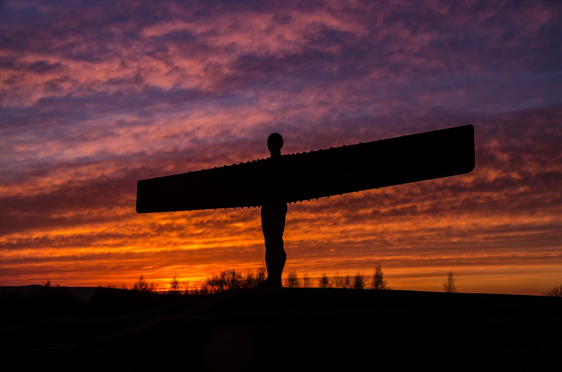 The Angel of the North at sunset The Angel of the North is a contemporary sculpture, designed by Antony Gormley, located in Gateshead,  England.Completed in 1998, it is a steel sculpture of an angel, 20 metres (66 ft) tall, with wings measuring 54 metres (177 ft) across. by philreay
