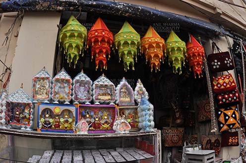 Festivals- Jagannath Rath Yatra (Odisha) Mementos of Lord Jagannath, Balbhadra and Subhadra, handicrafts and chandeliers , on display at the shop near Lord Jagannath Temple at Puri, Odisha, India. by Anil