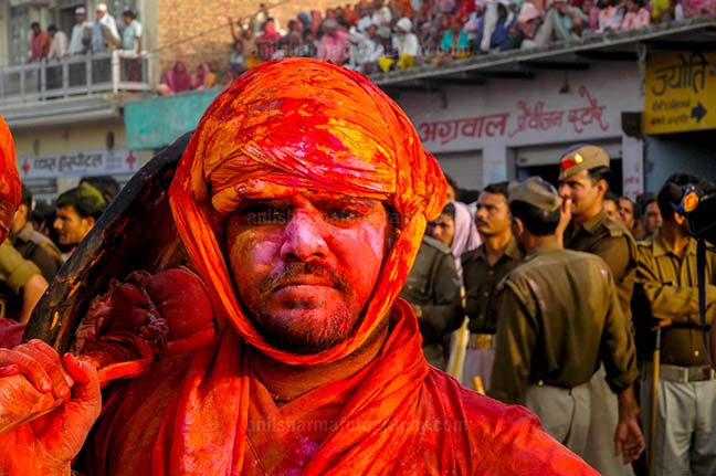 Festivals- Lathmaar Holi of Barsana (India) A man daubed in color powder during Lathmaar Holi at Barsana, Mathura, Uttar Pradesh, India. by Anil