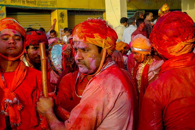 Festivals- Lathmaar Holi of Barsana (India) A man daubed in color powder holding bamboo stick during lathmaar Holi at Barsana, Mathura, Uttar Pradesh, India. by Anil