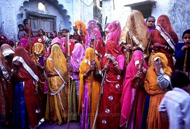 Festivals- Lathmaar Holi of Barsana (India) women's wearing colorful saree's holding bamboo sticks during Lathmaar Holi at Barsana, Mathura, Uttar Pradesh, India. by Anil