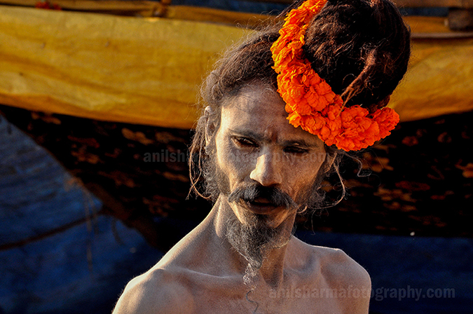 Culture- Naga Sadhu’s (India) A Naga Sadhu with fancy headdress of marigold flowers at Varanasi Ghats. by Anil