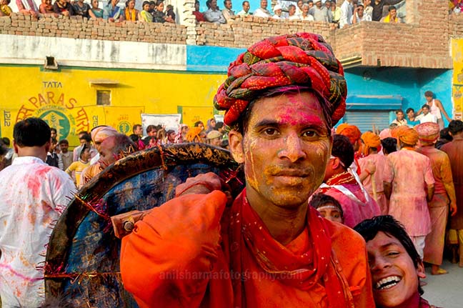Festivals- Lathmaar Holi of Barsana (India) A man daubed in color powder smiles as he celebrates lathmaar Holi at Barsana. by Anil