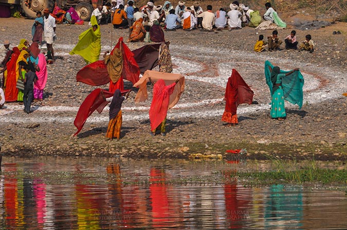 Fairs- Baneshwar Tribal Fair Baneshwar, Dungarpur, Rajasthan, India- February 14, 2011: Bhil women drying their saris after taking ritual bath at Baneshwar, Dungarpur, Rajasthan, India by Anil