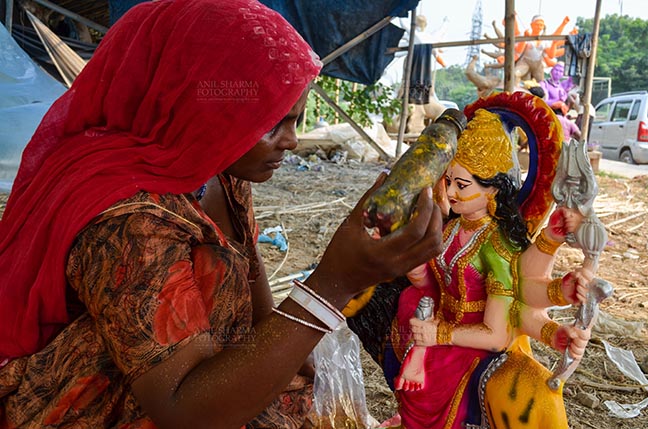 Festivals- Durga Puja Festival Durga Puja Festival, Noida, Uttar Pradesh, India- September 20, 2017: A Rajasthan tribal artist giving final touches to the Goddess Durga’s clay idol at Noida, Uttar Pradesh, India. by Anil