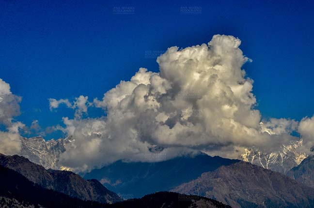 Clouds- Sky with Clouds (Panchchuli Peaks) Panchchuli Peaks, Uttarakhand, India- November 2, 2016: Dark blue sky with bright white clouds covering the snow covered Punchchuli Peaks, view from Munsiyari, Uttarakhand, India. by Anil