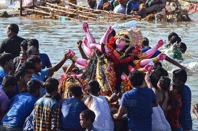 Festivals- Durga Puja Festival, New Delhi, India. (Photo: Anil Sharma) Durga Puja, New Delhi, India- September 30, 2017: Hindu devotees immersing the idol of Goddess Durga in the river Yamuna at Kalindi Kunj, New Delhi, India. by Anil