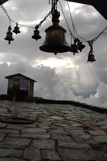 Religion- Tungnath Temple, Uttarakhand (India) Tungnath, Chopta, Uttarakhand, India- August 18, 2009: Sun piercing the cloudes and temple bells at Tungnath Temple, Chpota, Uttarakhand, India. by Anil