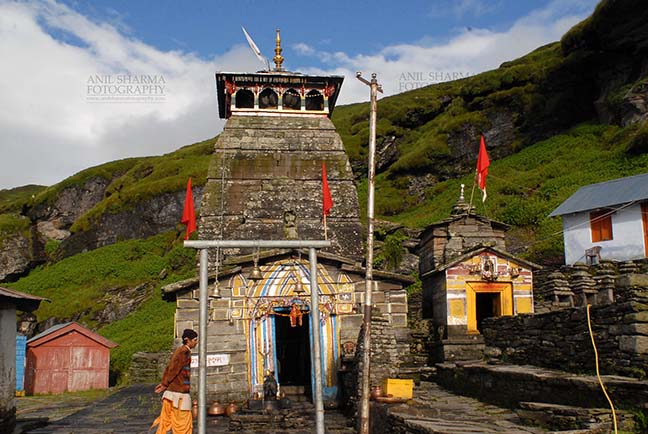 Religion- Tungnath Temple, Uttarakhand (India) Tungnath, Chopta, Uttarakhand, India- August 18, 2009: Hanging bells, red color flags and temple prist at Tungnath temple complex at Tungnath, Chpota, Uttarakhand, India. by Anil