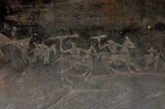 Archaeology- Bhimbetka Rock Shelters (India) Prehistoric Rock Painting of Warriors on horses in the battle-field at Bhimbetka archaeological site, Raisen, Madhya Pradesh, India by Anil