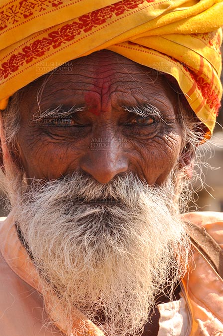 Fairs- Baneshwar Tribal Fair, Dungarpur, Rajasthan, India. (Photo: Atul Sharma) Baneshwar, Dungarpur, Rajasthan, India- February 14, 2011: An old Bhil devotee at the Mahadev temple at Baneshwar Dungarpur, Rajasthan, India. by Anil