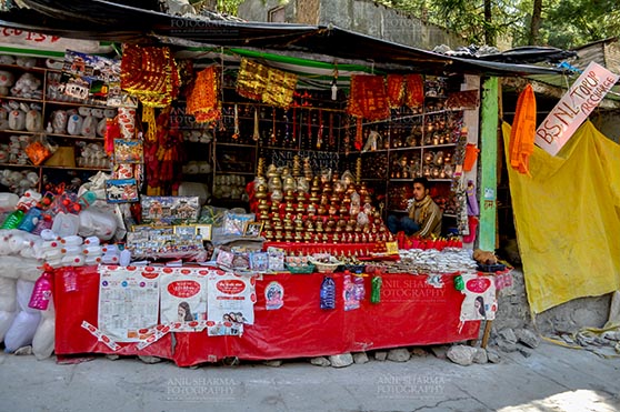Travel- Gangotri Temple, Gangotri, Uttarkashi, Uttarakhand, India. (Photo: Anil Sharma) Gangotri, Uttarakhand, India- May 13, 2015: A shopkeepers selling plastic bottles and devotional objects, for religious ceremonies at Gangotri, Uttarakhand, India. by Anil