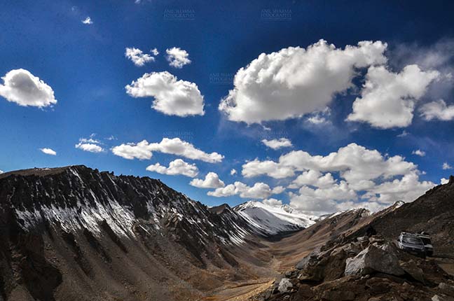 Clouds- Sky with Clouds (Khardung La) Khardung La, India- September 30, 2014: Blue sky with clouds over the snow-covered peaks at Khardung La, Ladakh, India. (Photo By Atul Sharma) by Anil