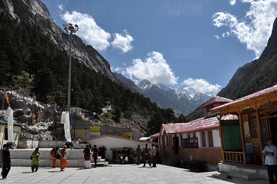 Travel- Gangotri Temple, Gangotri, Uttarkashi, Uttarakhand, India. (Photo: Anil Sharma) Gangotri, Uttarakhand, India- May 13, 2015: Hindu Devotees at the Goddess Ganges Temple and snow-covered peaks at Bhagirathi valley at Gangotri, Uttarakhand, India. by Anil