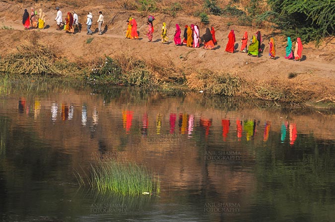 Fairs- Baneshwar Tribal Fair Baneshwar, Dungarpur, Rajasthan, India- February 14, 2011: reflection of devotees in the Holy River water at Baneshwar, Dungarpur, Rajasthan, India by Anil