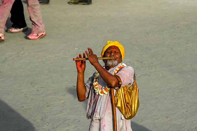 Festivals- Lathmaar Holi of Barsana (India) An old men playing flute at Barsana, Mathura, India. by Anil