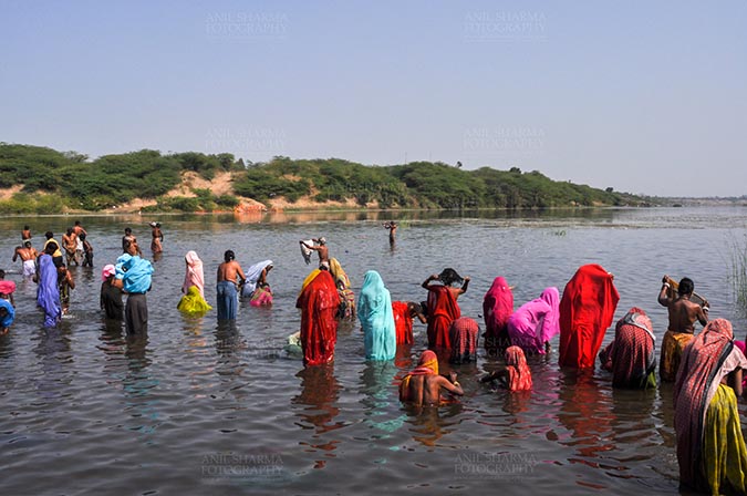 Fairs- Baneshwar Tribal Fair, Dungarpur, Rajasthan, India. (Photo: Atul Sharma) Baneshwar, Dungarpur, Rajasthan, India- February 14, 2011: Devotees ready for the traditional ritual bath at the confluence of the rivers, Mahi and Som at Baneshwar, India. by Anil