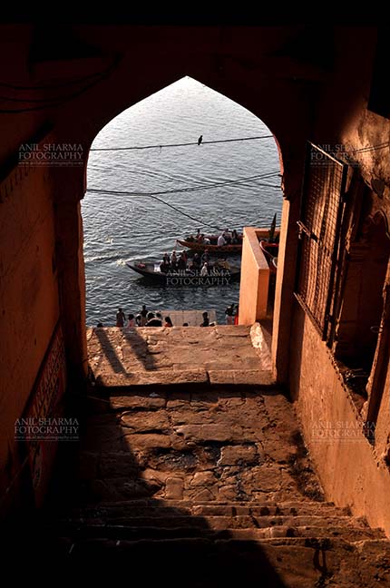 Travel- Varanasi the city of light (India) View from an old building gates some pilgrims using boats to cross Holy River Ganges to reach their destination at Varanasi, Uttar Pradesh, India. by Anil