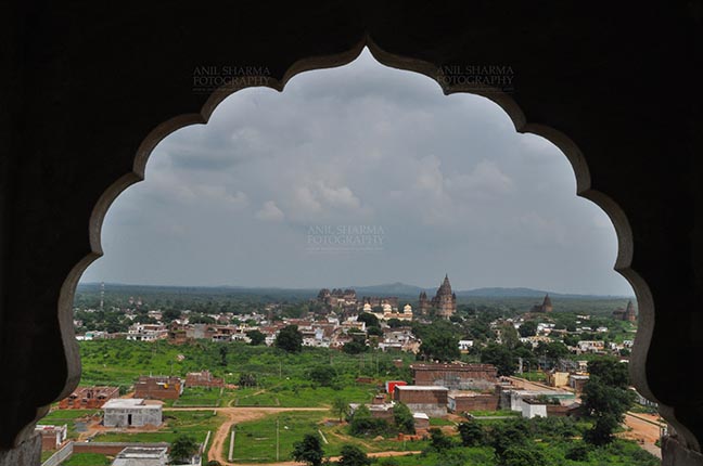 Monuments- Palaces and Temples of Orchha Orchha, Madhya Pradesh, India- August 20, 2012: View from a carved window of Laxmi Temple, Chaturbhuj temple is seen in the distance, Orchha, Madhya Pradesh, India. by Anil