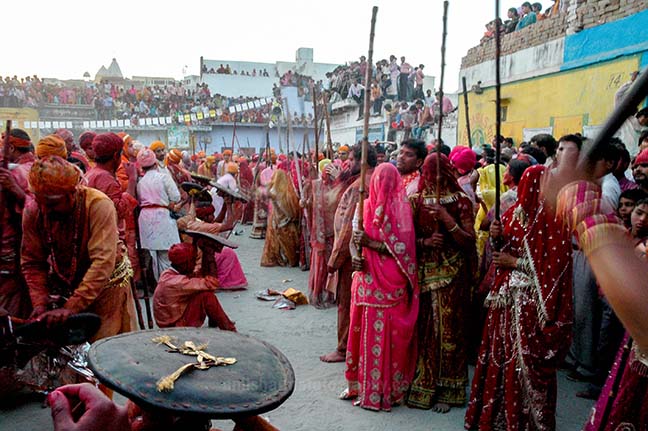 Festivals- Lathmaar Holi of Barsana (India) women's wearing colorfull saree's holding bamboo sticks during Lathmaar Holi at Barsana, Mathura, Uttar Pradesh, India. by Anil