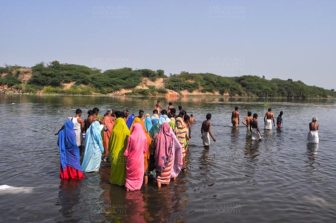 Fairs- Baneshwar Tribal Fair Baneshwar, Dungarpur, Rajasthan, India- February 14, 2011: Devotees ready for the traditional ritual bath at the confluence of the rivers, Mahi and Som at Baneshwar, Dungarpur, Rajasthan, India by Anil