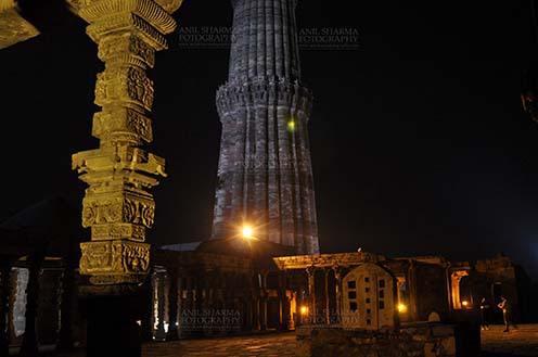 Monuments- Qutab Minar in Night, New Delhi, India. An ornately carved pillar at the Quwwat-Ul-Islam mosque in night at Qutub Minar Complex, Mehrauli , New Delhi, India. by Anil