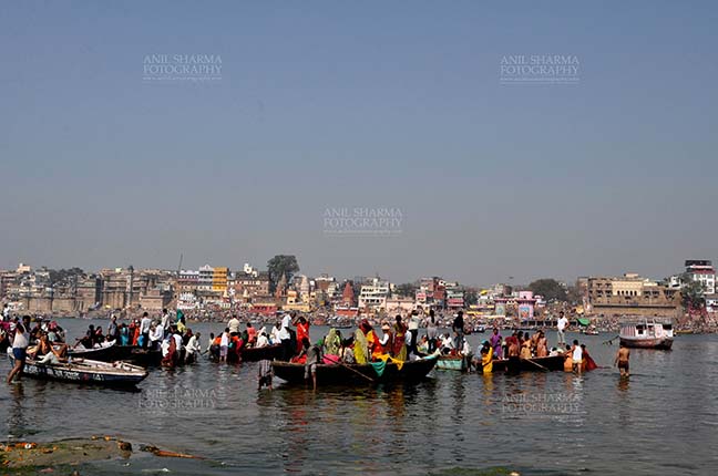 Travel- Varanasi the city of light (India) A panoramic view of Varanasi Ghats- Sadhu’s and devotee’s using boats to cross Holy River Ganga at Varanasi, Uttar Pradesh, India. by Anil