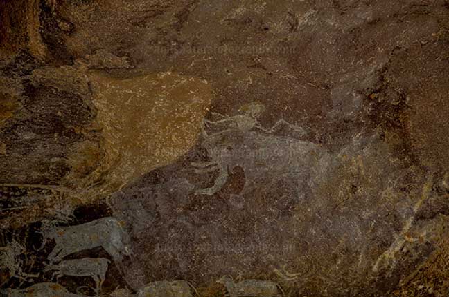 Archaeology- Bhimbetka Rock Shelters Raisen, Madhya Pradesh, India. (Photo: Anil Sharma) Prehistoric Rock Painting: a man with an elephant baby at the Bhimbetka archaeological site, Raisen, Madhya Pradesh, India. by Anil