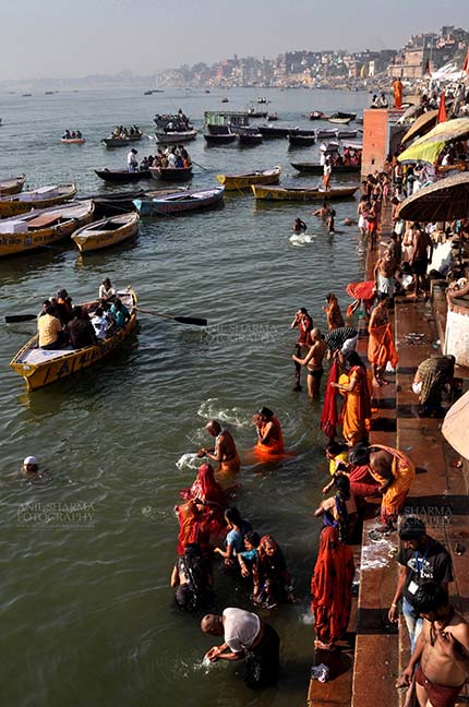 Travel- Varanasi the city of light (India) Hindu devotees praying in knee deep Ganga water at Ghats at Varanasi, Uttar Pradesh, India. by Anil