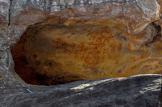 Archaeology- Bhimbetka Rock Shelters (India) Prehistoric rock painting showing chief of warrior’s leading his team at Bhimbetka archaeological site, Raisen, Madhya Pradesh, India by Anil