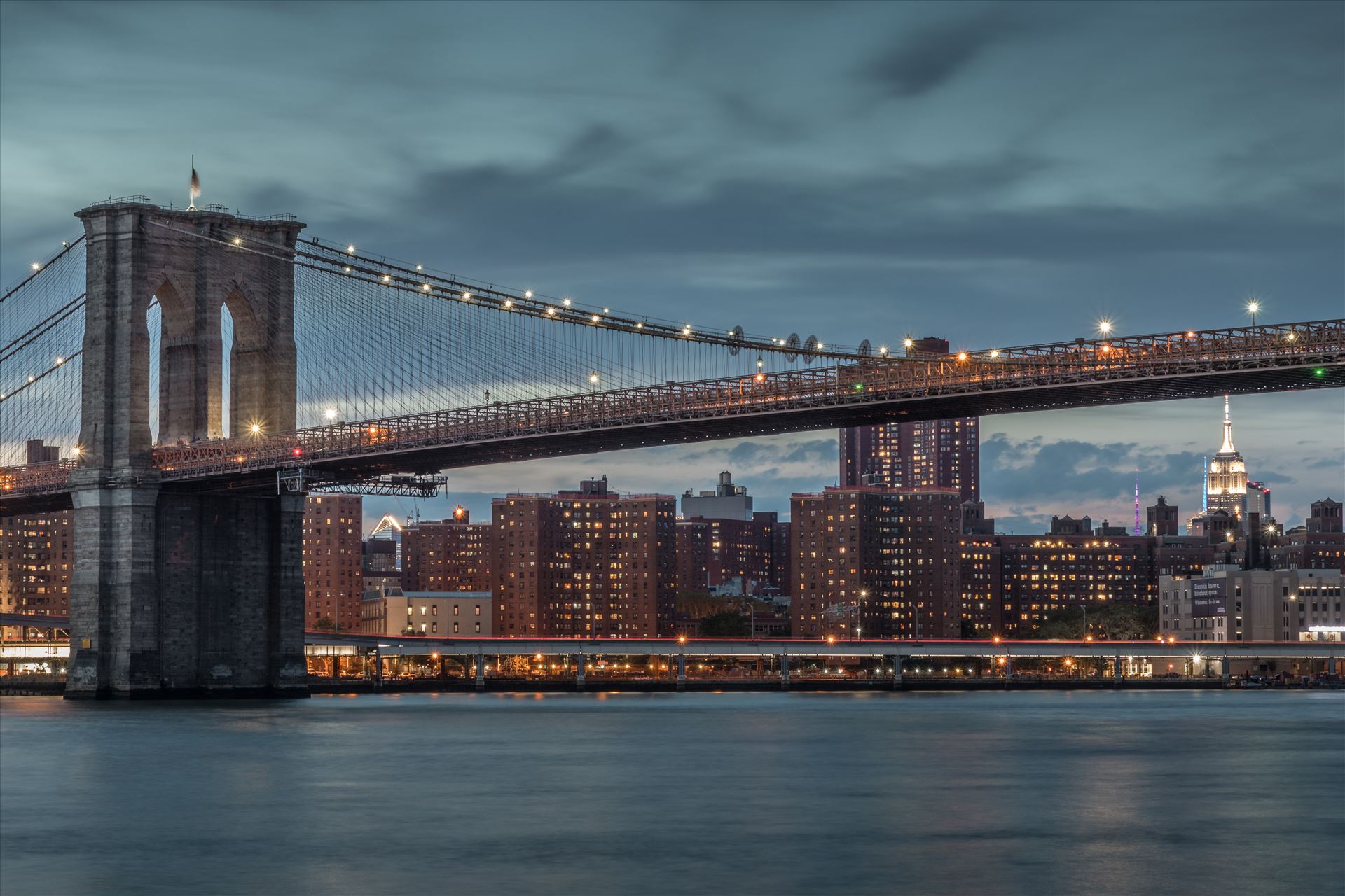 Brooklyn Bridge in New York The iconic Brooklyn Bridge in New York spanning the East River between Brooklyn and Lower Manhattan with the Empire State Building in the distance on the right. by Tony Keogh Photography