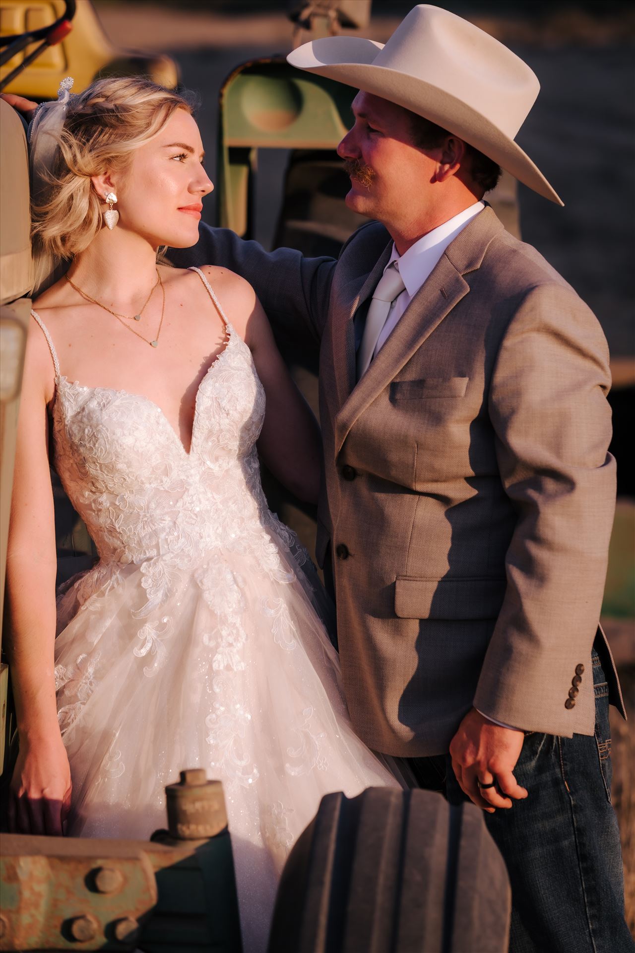 FW-1020.JPG Sarah Williams of Mirror's Edge Photography, a San Luis Obispo and Santa Barbara County Wedding and Engagement Photographer, captures Katie and Joe's country chic wedding in Lompoc, California.  Cowboy wedding, bride and groom pose next to tractor. by Sarah Williams