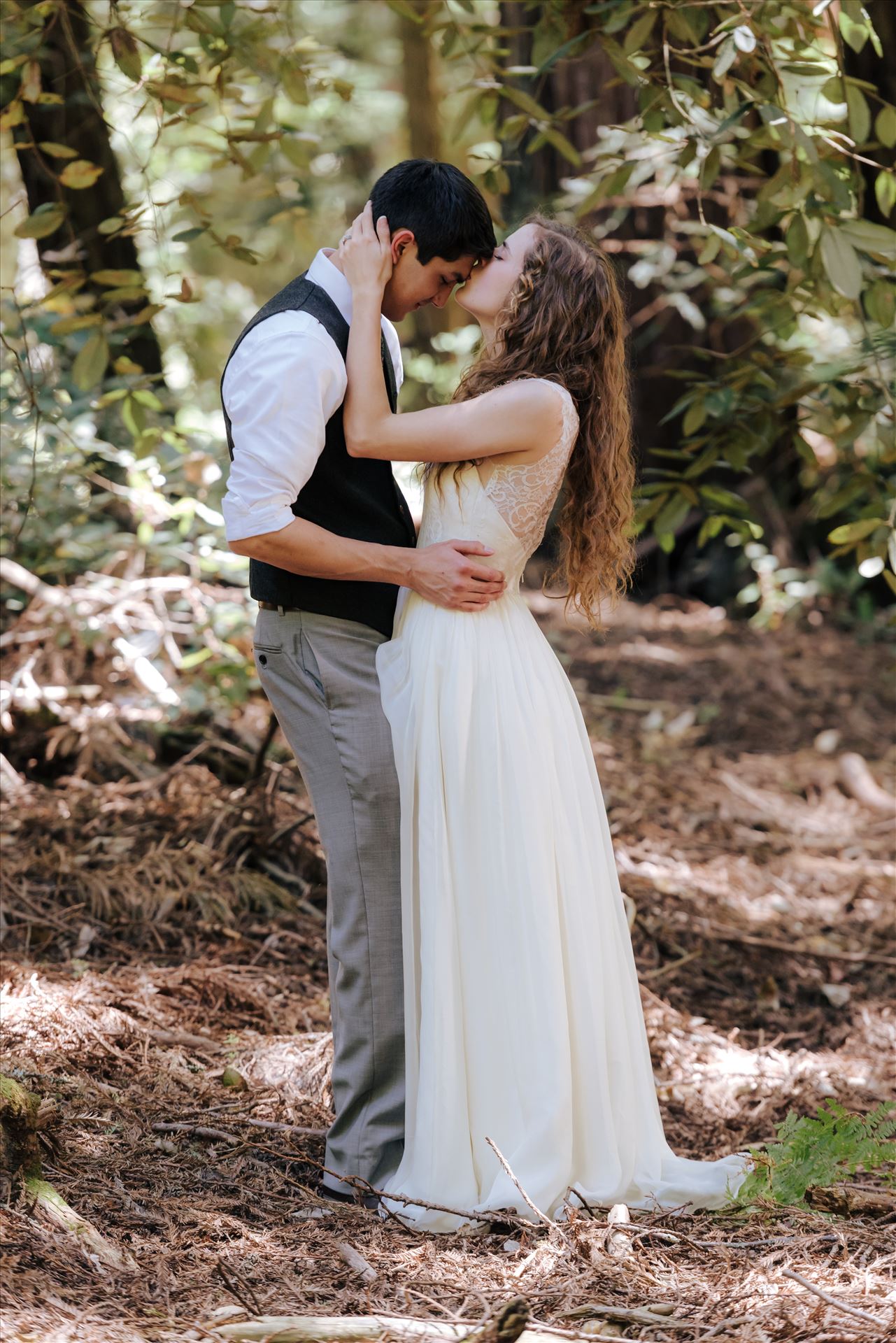 FW-6044.JPG Mt Madonna wedding in the redwoods outside of Watsonville, California with a romantic and classic vibe by sarah williams of mirror's edge photography a san luis obispo wedding photographer.  Bride kisses groom in the trees by Sarah Williams