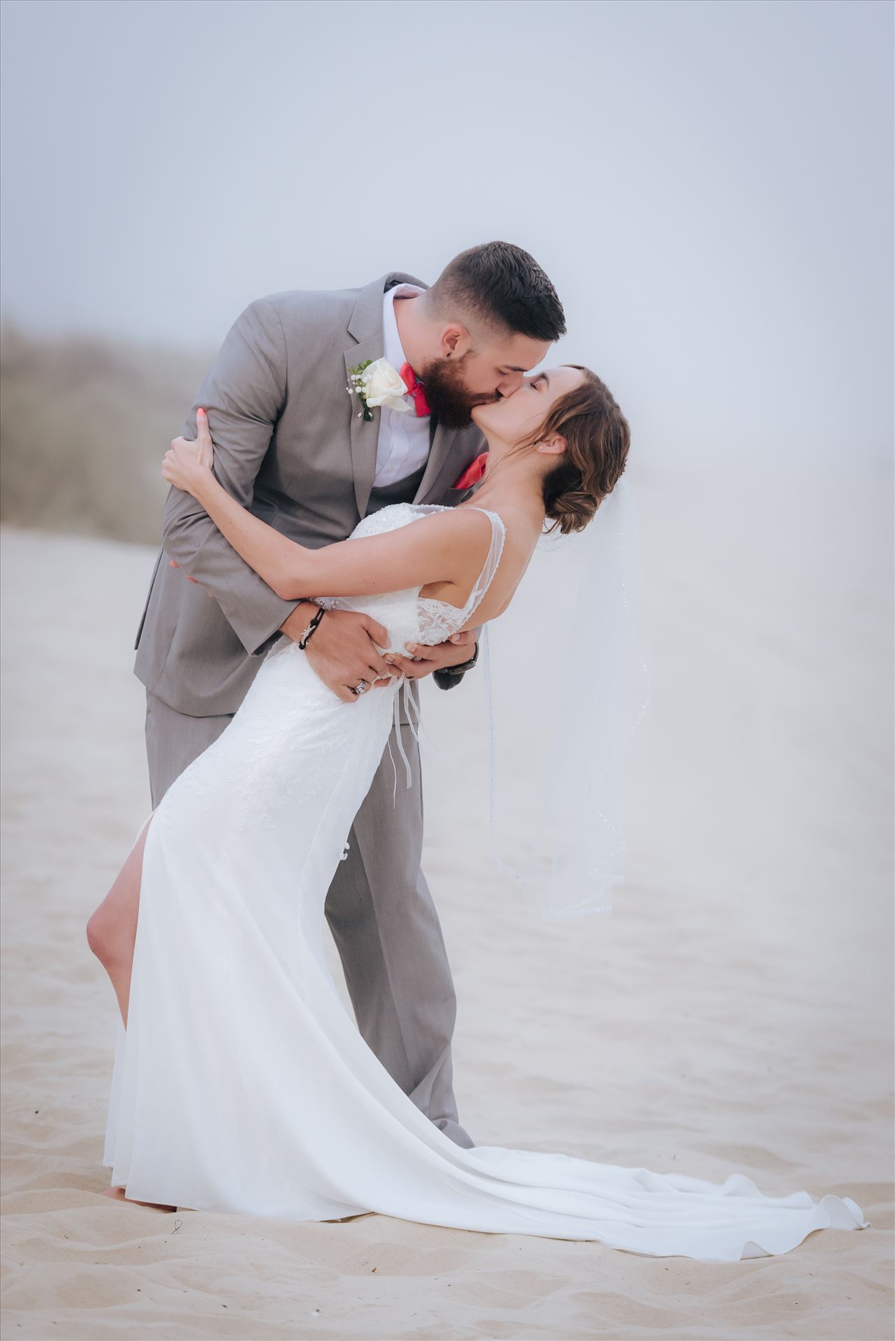 FW-8130.jpg Romantic wedding in the sand on Grover Beach in California.  Barefoot with surfboards and driftwood, tent and ceremony set up by Beach Butlerz, wedding photography by Mirror's Edge Photography.  Romantic Bride and Groom dip in the fog by Sarah Williams