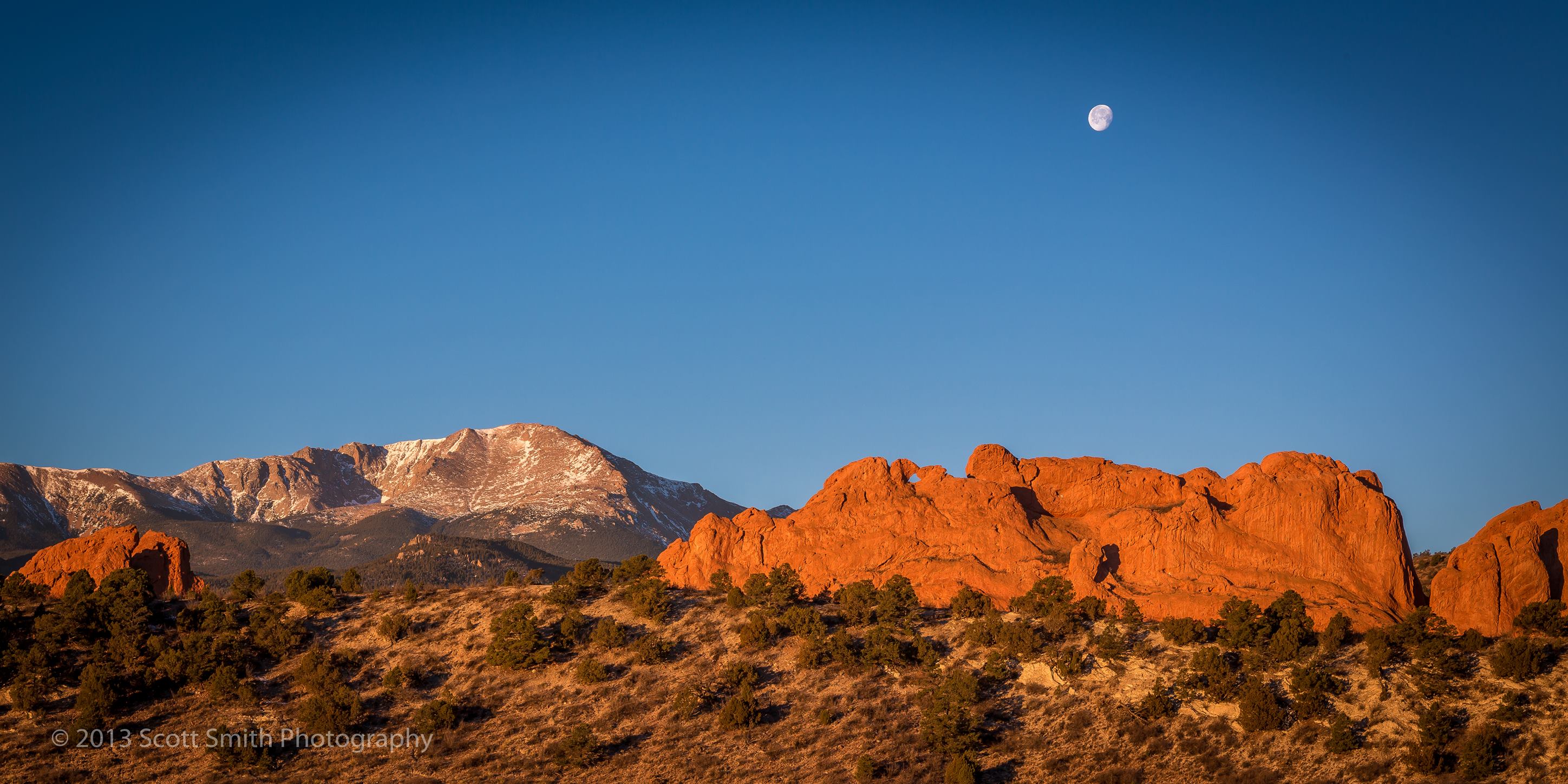 Sun Rising, Moon Setting The moon sets as the morning sun lights up the Garden of the Gods and Pike's Peak in Manitou Springs, Colorado. by Scott Smith Photos