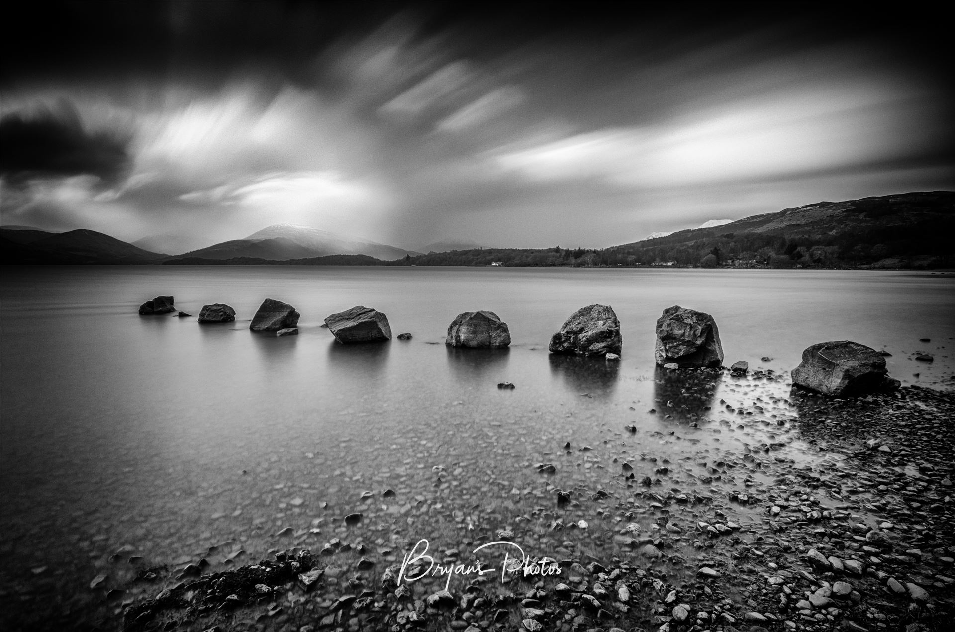 Rocks At Milarrochy A black and white long exposure photograph of Loch Lomond taken from Milarrochy Bay. by Bryans Photos