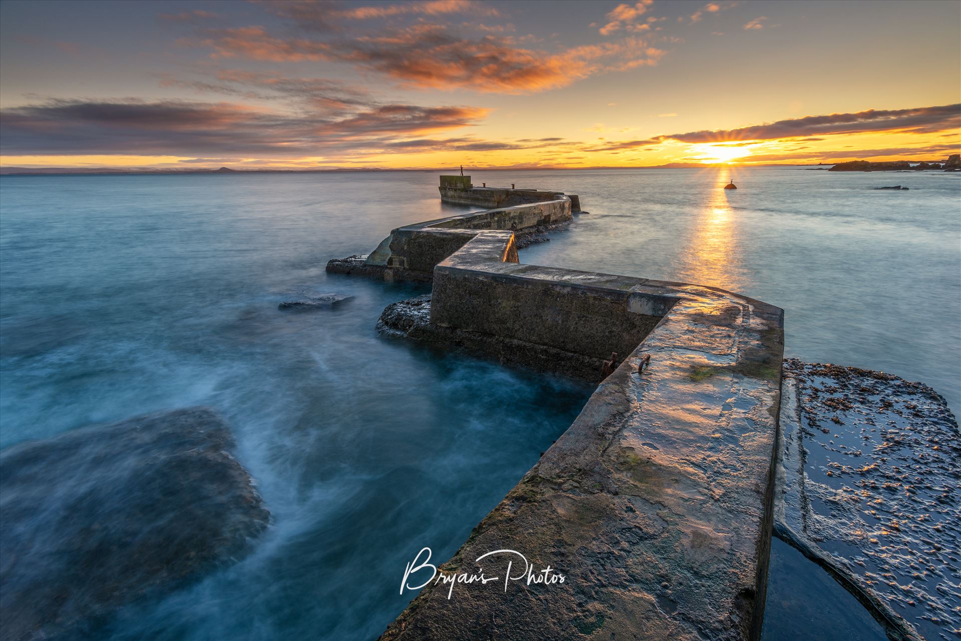 East Neuk Sunset A photograph of the St Monans breakwater taken at Sunset. by Bryans Photos