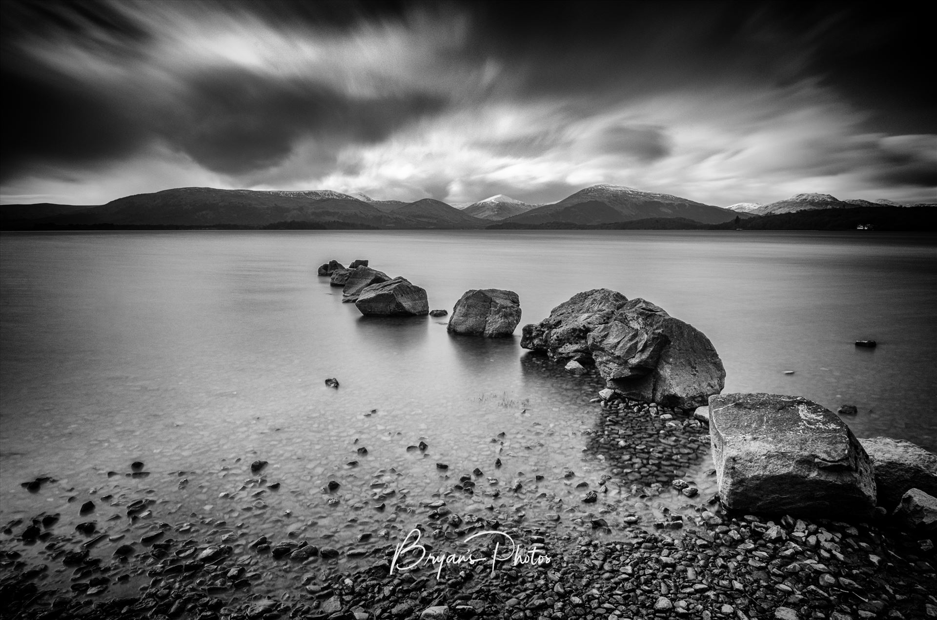 Milarrochy Bay Loch Lomond A black and white long exposure photograph of Loch Lomond taken from Milarrochy Bay. by Bryans Photos