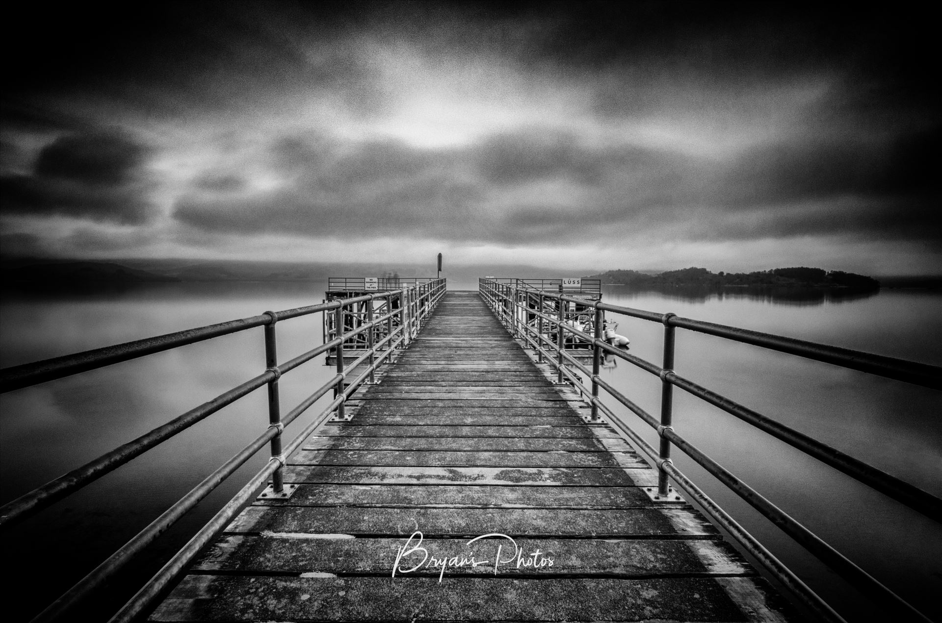 Luss Pier A black and white long exposure photograph of Luss Pier on the banks of Loch Lomond. by Bryans Photos