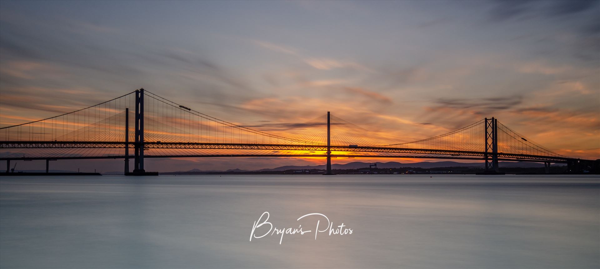 Road Bridges at Sunset A photograph of the Forth Road Bridge and Queensferry crossing taken at sunset from Hawes Pier South Queensferry. by Bryans Photos