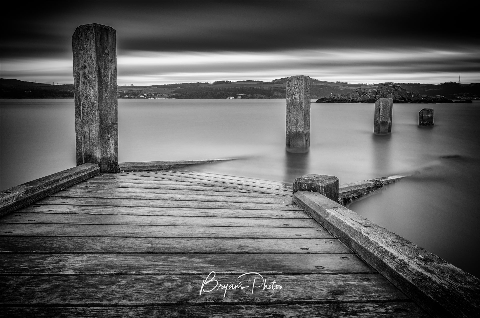 Inchcolm Jetty A black and white long exposure photograph taken from the jetty at Inchcolm Island looking towards the Fife coast. by Bryans Photos