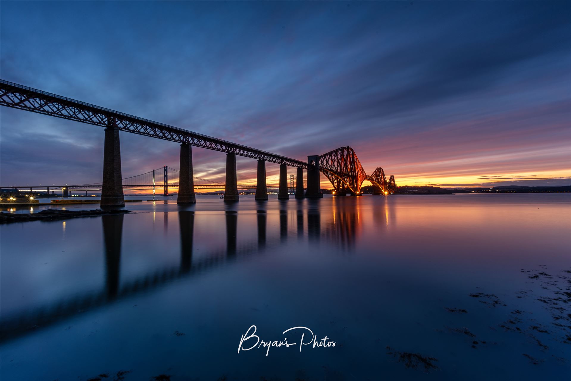 South Queensferry Sunset A photograph of the Forth Rail Bridge taken at sunset from the banks of the river Forth at South Queensferry. by Bryans Photos