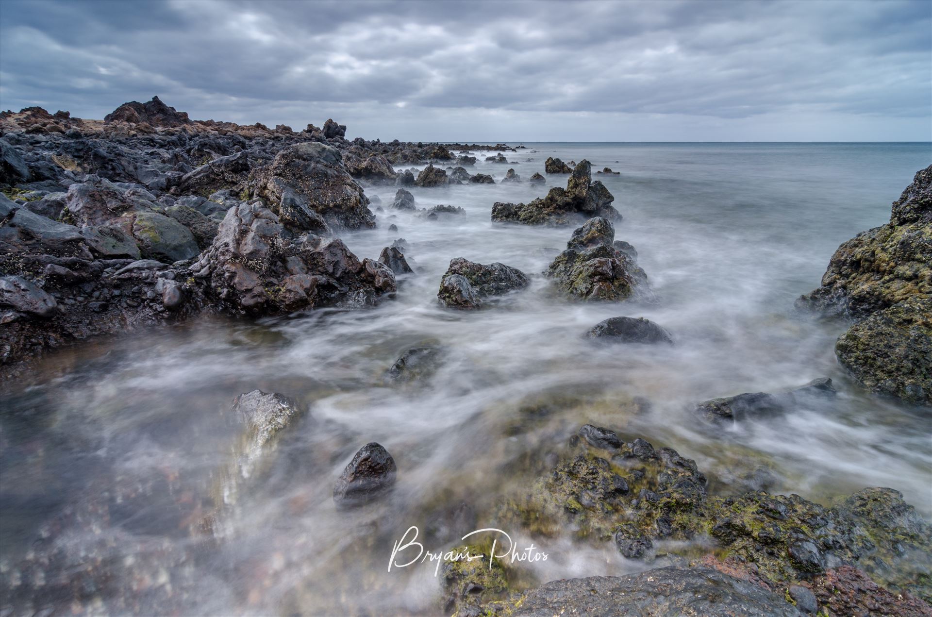 Volcanic Seascape A photograph taken from the beach at Los Piccolos Lanzarote looking out over the Atlantic Ocean. by Bryans Photos