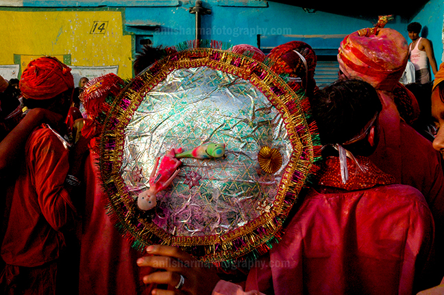 Festivals- Lathmaar Holi of Barsana (India) A man daubed in color powder holding shield during Lathmaar Holi celebration at Barsana, Mathura Uttar Pradesh, India. by Anil Sharma Photography